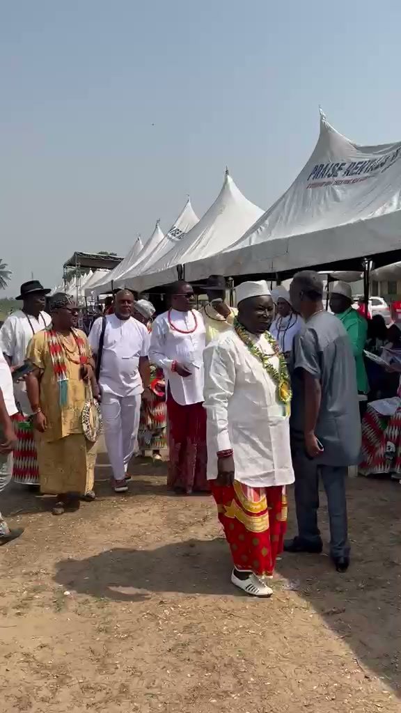 Chiefs in white and coral walking past the festival tents.