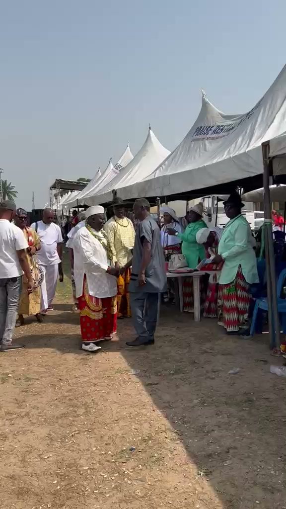 The line of white festival tents with guests in traditional dress gathering in front.